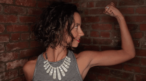 Female builder flexes biceps trash