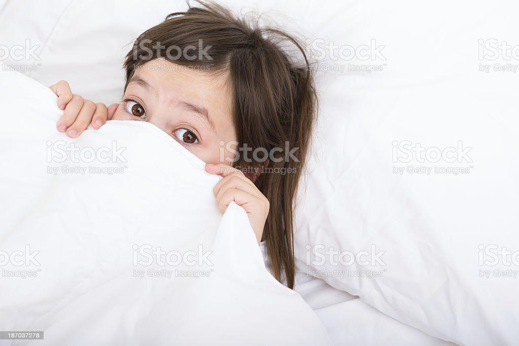 Girl laying in bed scared